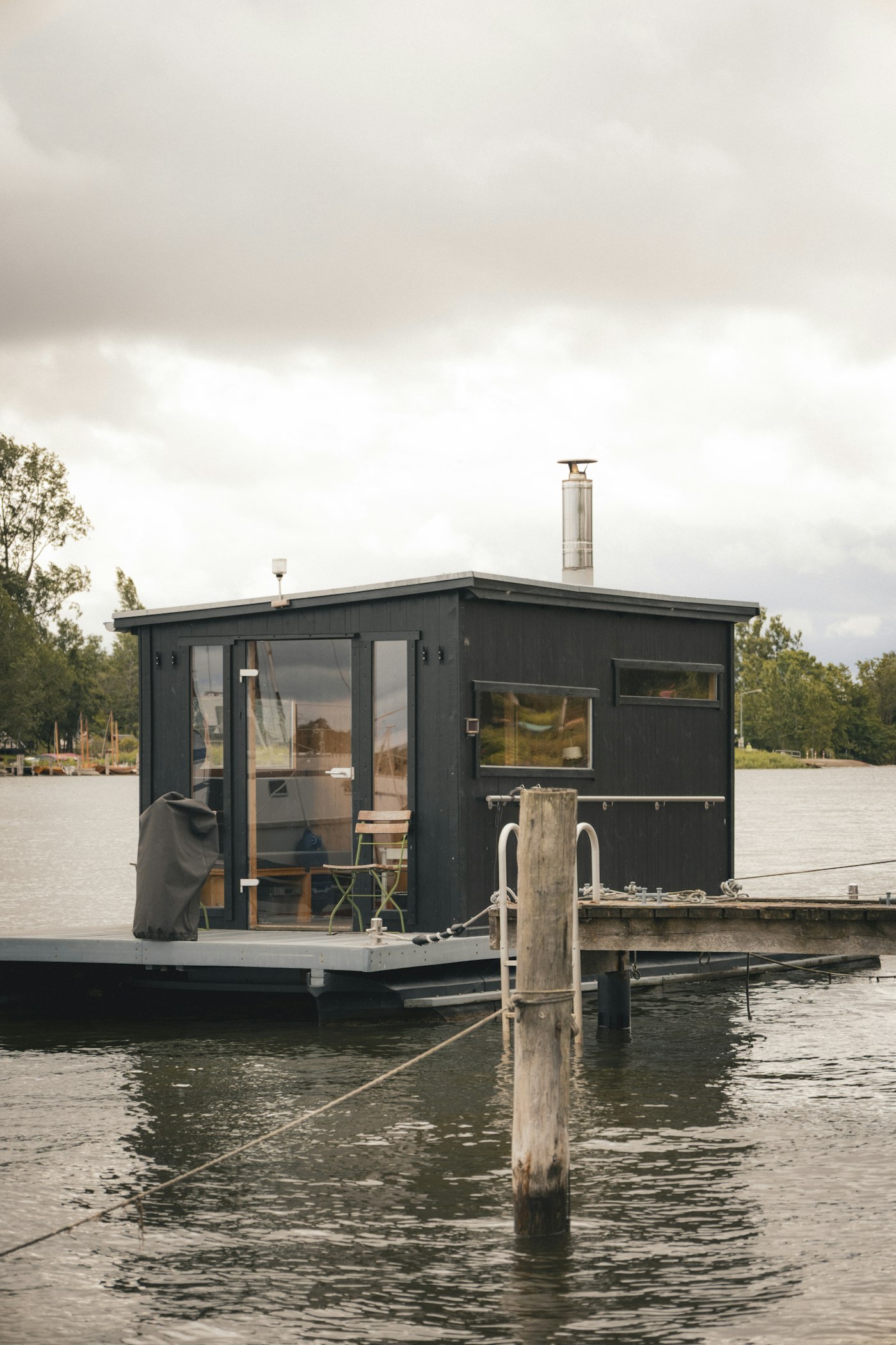 水際に浮かぶ、黒い木の壁のサウナ小屋